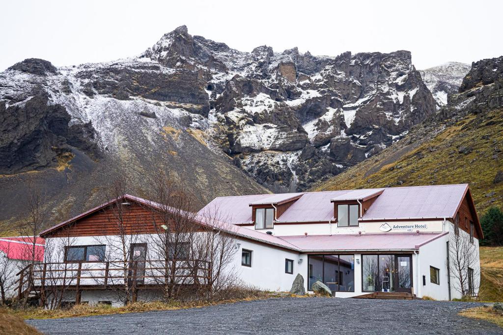 霍夫Adventure Hotel Hof的一座白楼,背景是一座山