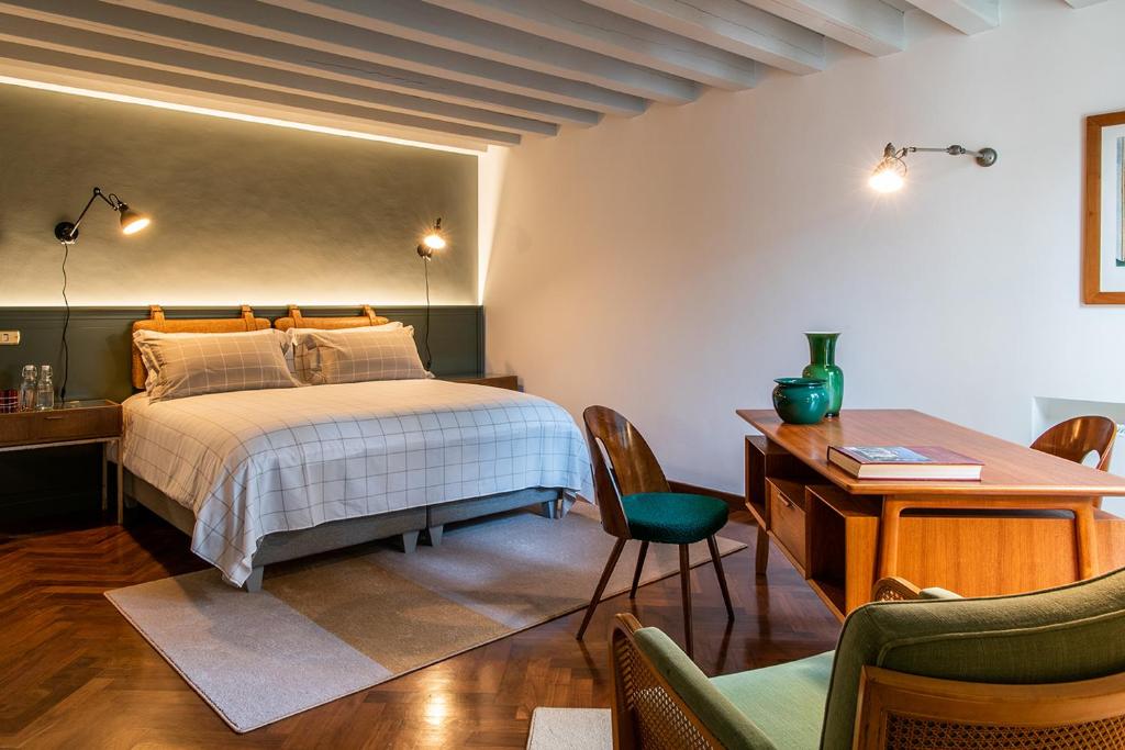 帕多瓦Casa Giotto的卧室配有一张床、一张桌子和椅子