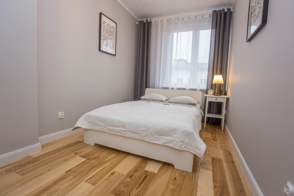比亚韦斯托克CR Apartament w sercu miasta Lipowa 1的白色的卧室设有床和窗户