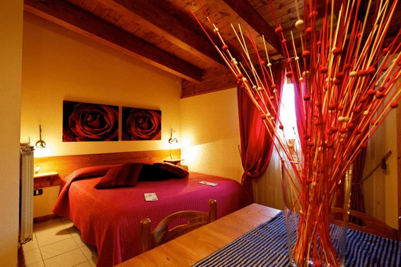 瓦伦扎诺瓦伦蒂诺酒店的一间卧室,配有一张床和一张桌子上的花瓶