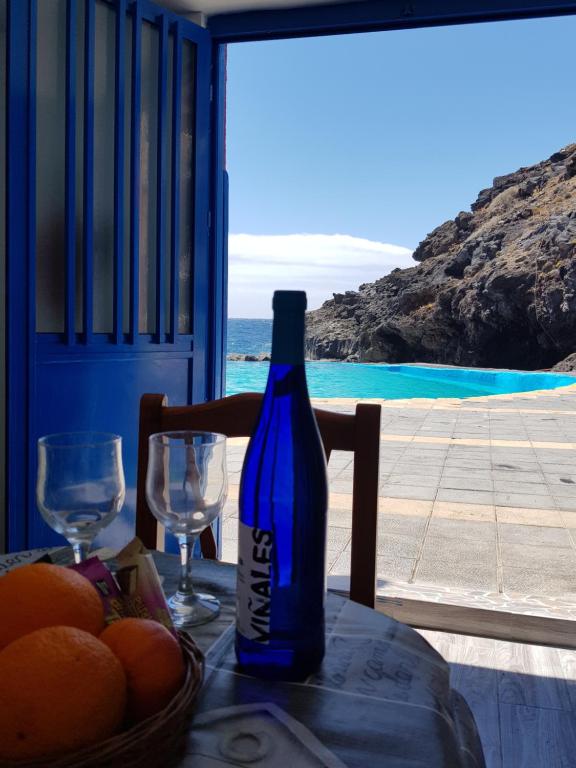 圭马尔Sueño de Mar的一瓶葡萄酒,坐在桌子上,放着一篮橘子