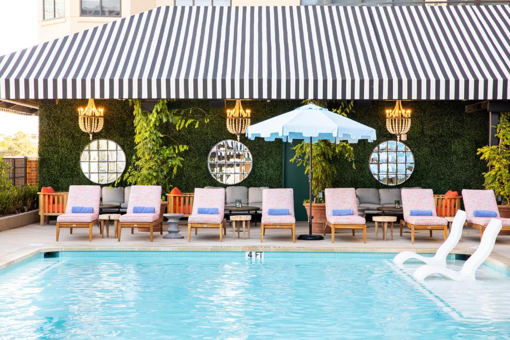 奥斯汀Hotel ZaZa Austin的一个带桌椅的庭院和一个游泳池