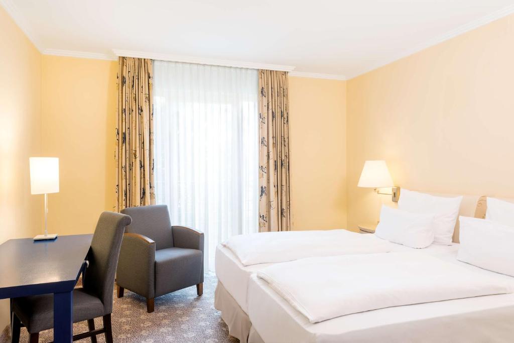 波茨坦波茨坦NH酒店的酒店客房配有两张床和一张书桌