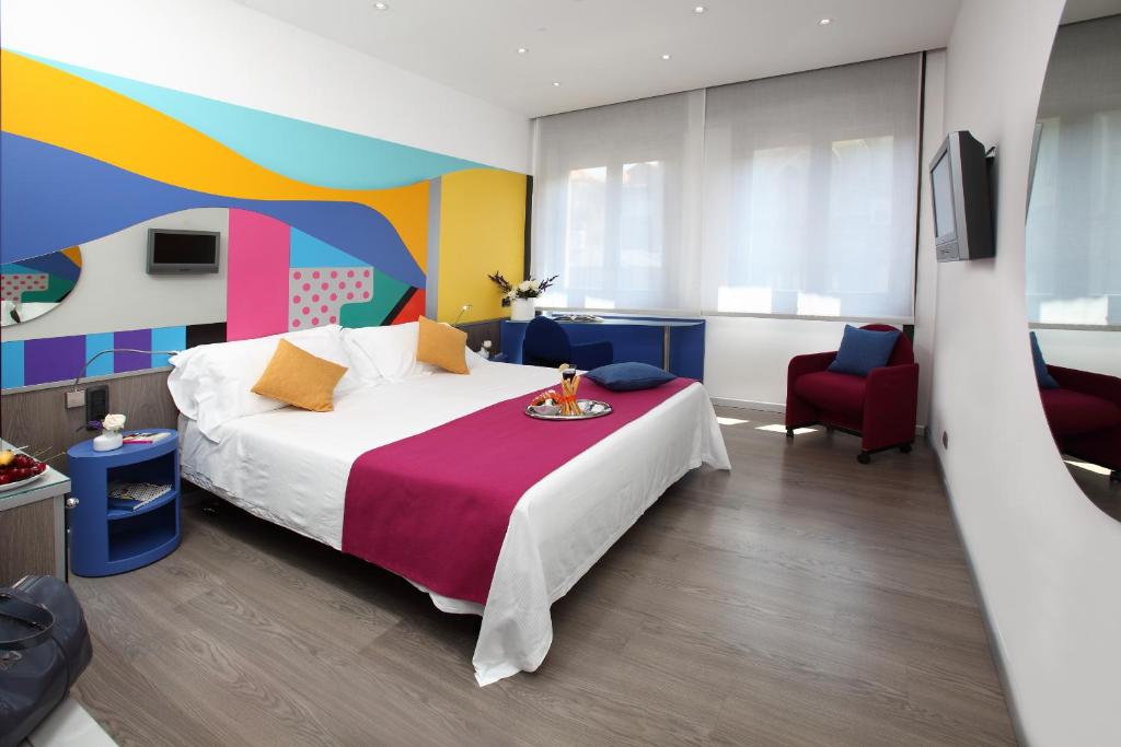 米兰梅迪奥兰酒店的一间卧室设有一张床和色彩缤纷的墙壁
