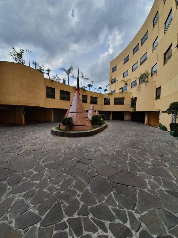 墨西哥城HOTEL VALLE DEL SUR的庭院中间有雕像的建筑