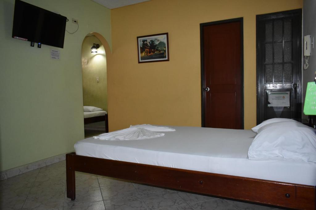伊瓦格LA POSADA DEL VIAJERO的一间卧室配有一张床和一台电视。