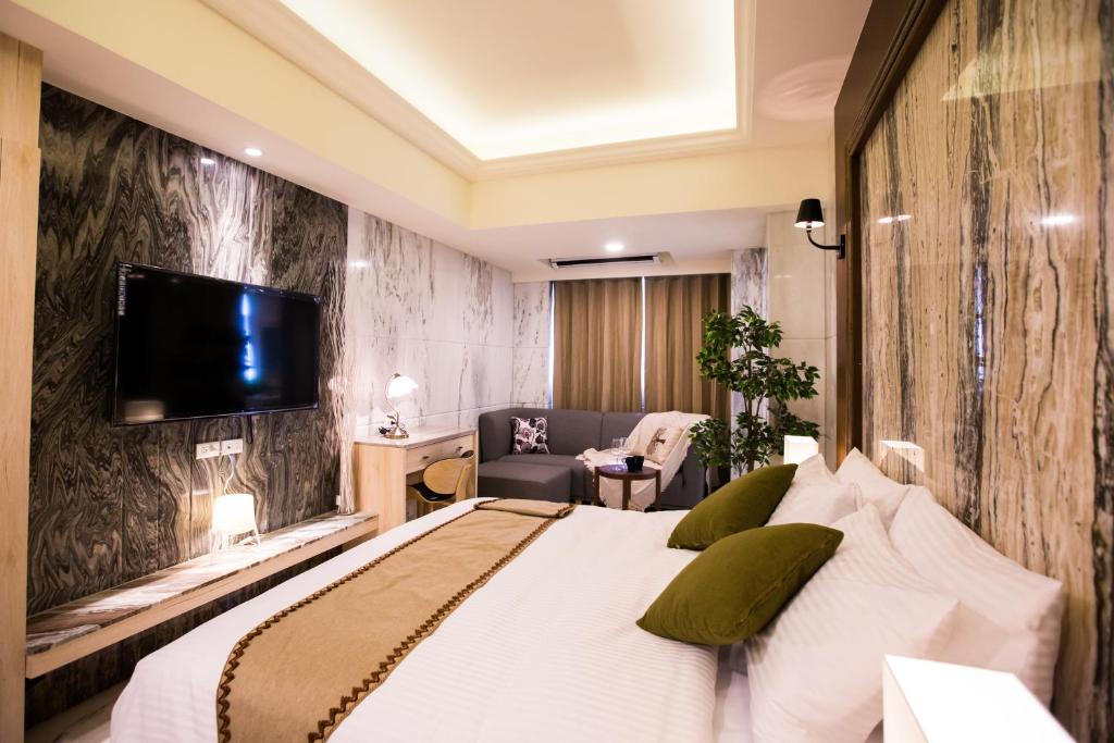 台中市枫华沐月台湾大道行馆的一间卧室配有一张床,墙上配有电视