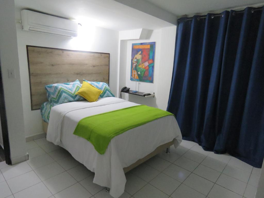 巴拿马城SERENADE Lodging Rooms的一间卧室配有一张带绿毯的大床