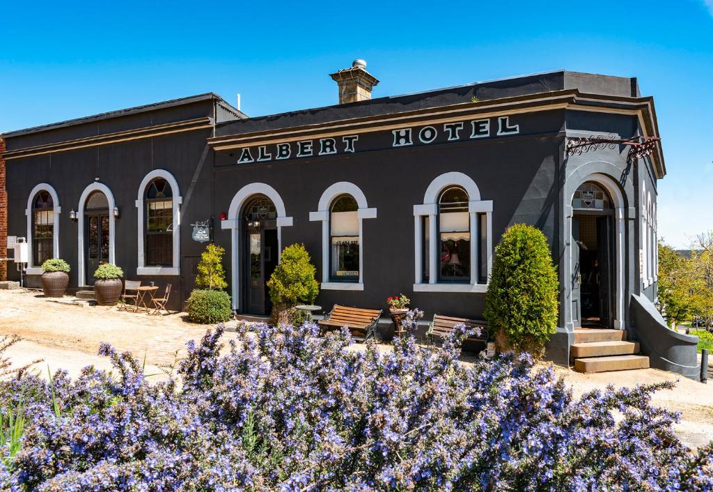 戴尔斯福特Albert Hotel Daylesford的黑色酒店前面有紫色的鲜花