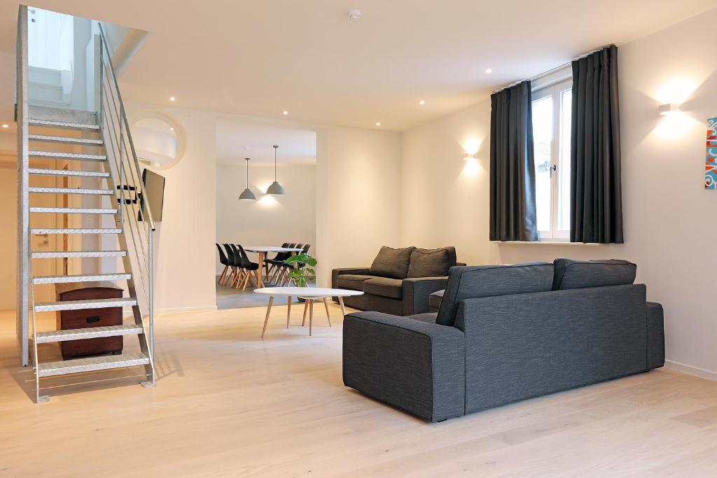 弗尔内Loft vakantiehuis的客厅设有黑色沙发和楼梯。