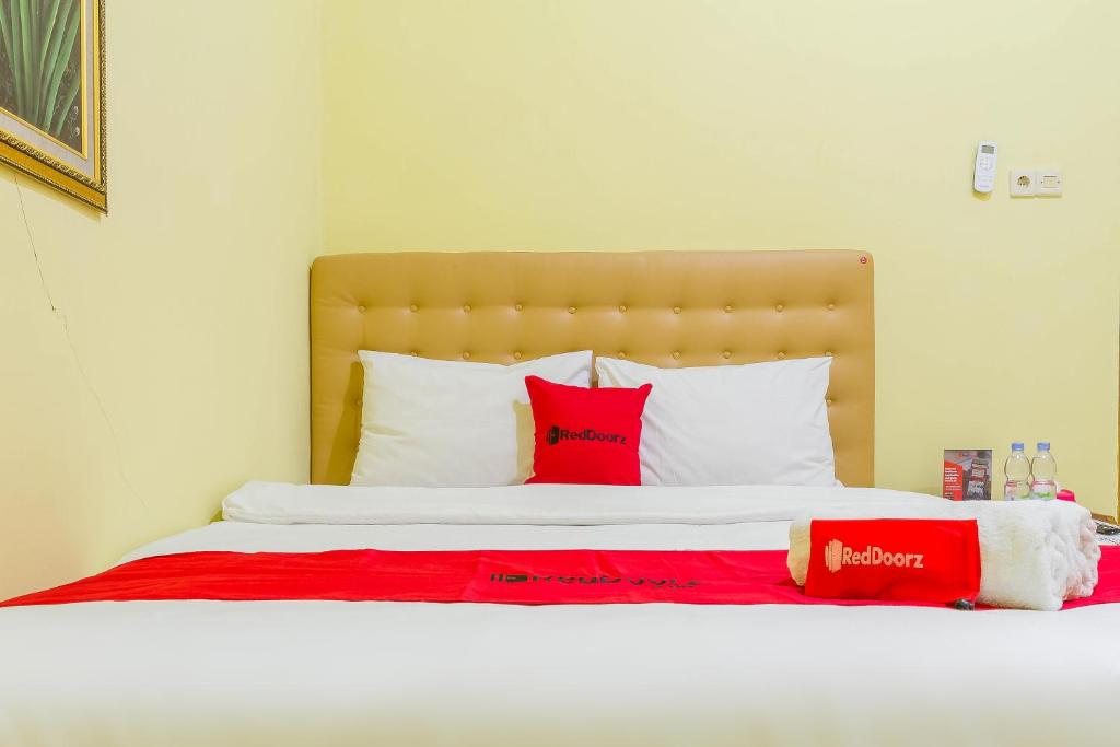 井里汶RedDoorz Syariah @ Puri Kalijaga Street的一张带红色和白色枕头的床
