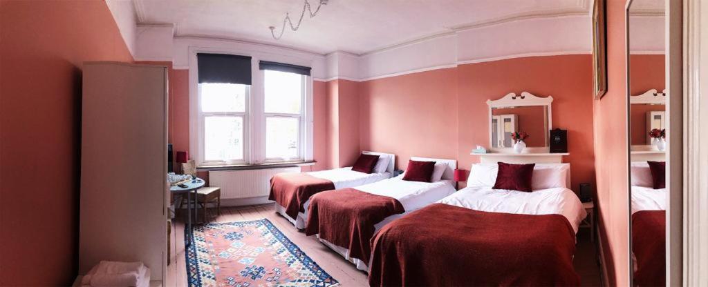 伦敦里海旅馆的红色墙壁客房的两张床