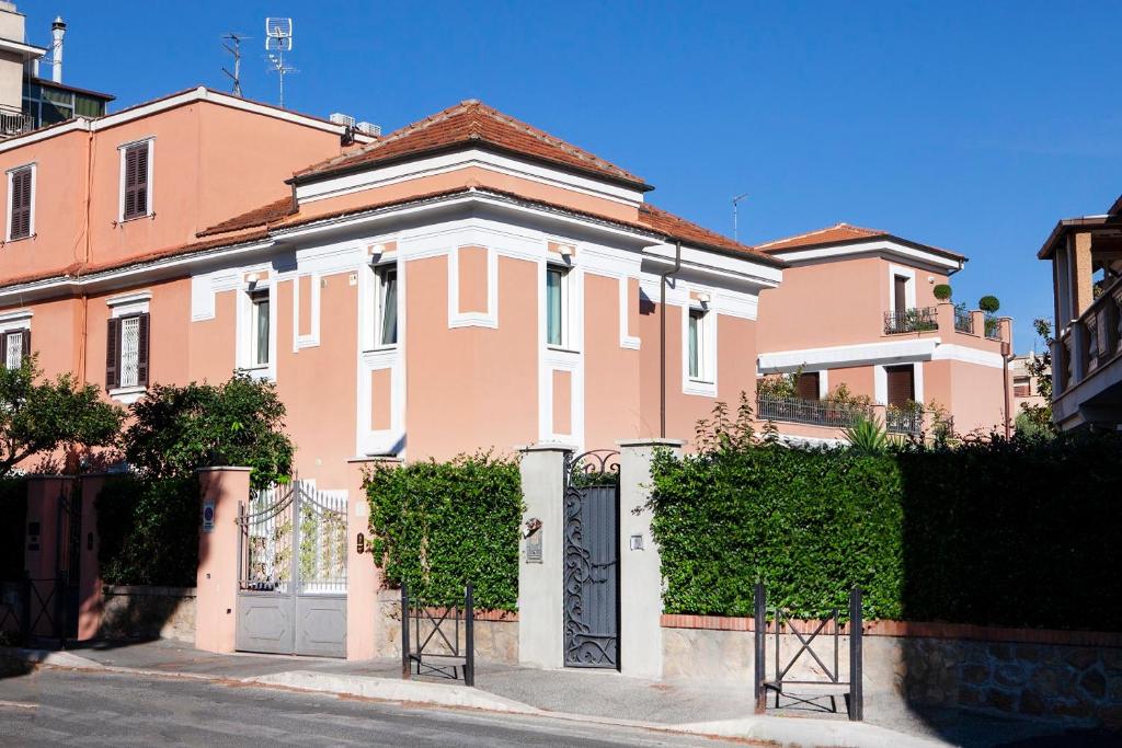 罗马I Villini del Pigneto的粉红色的房子,前面有一个门