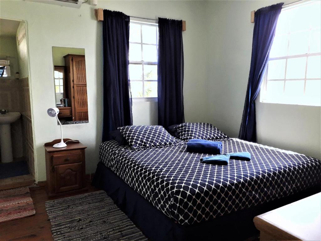 Buccoo米勒旅馆的一间卧室配有一张带黑白色棉被的床