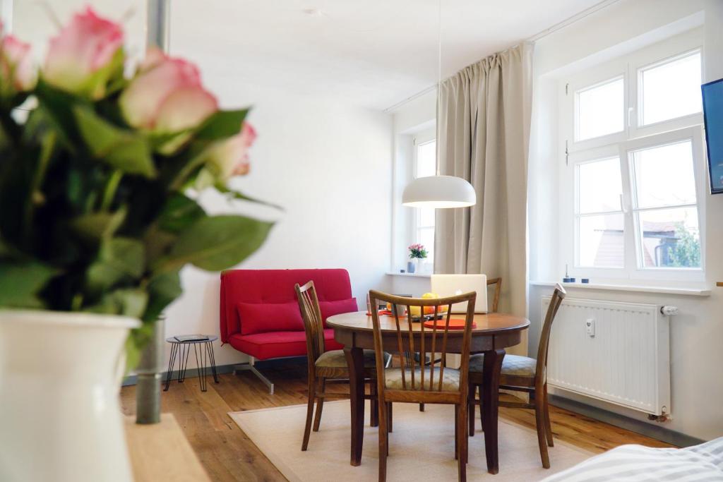 萨勒河畔瑙姆堡Apartment Dompredigergasse的客厅配有桌椅和红色沙发