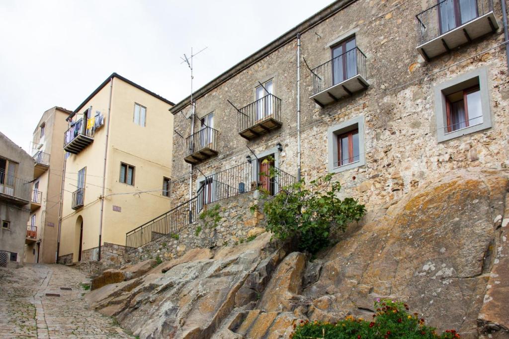 Geraci SiculoCasa vacanze Ai Valàti CIR 19082-037C20-6280的一座古老的石头建筑,位于一座拥有建筑的山丘上