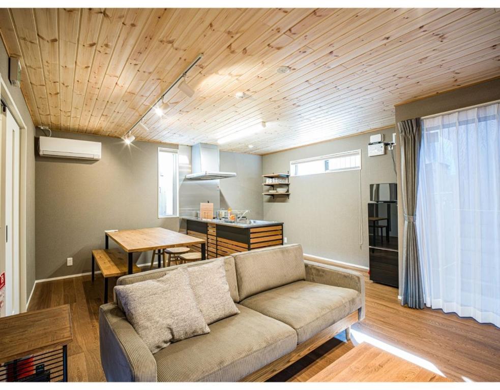松江市Rakuten STAY HOUSE x WILL STYLE Matsue 103的带沙发的客厅和用餐室