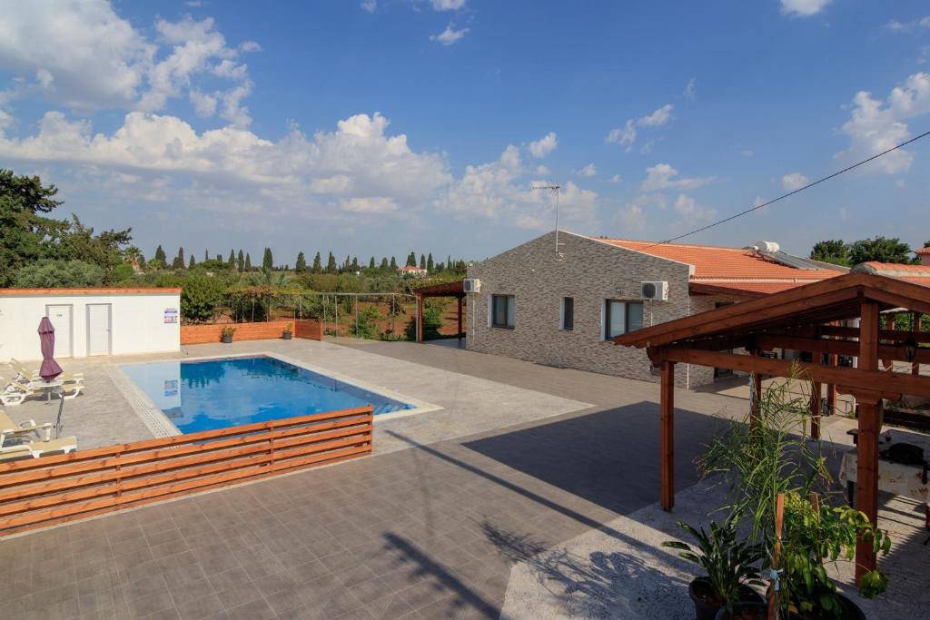 皮尔瓦利亚BerryRose Villa的一个带游泳池和房子的后院