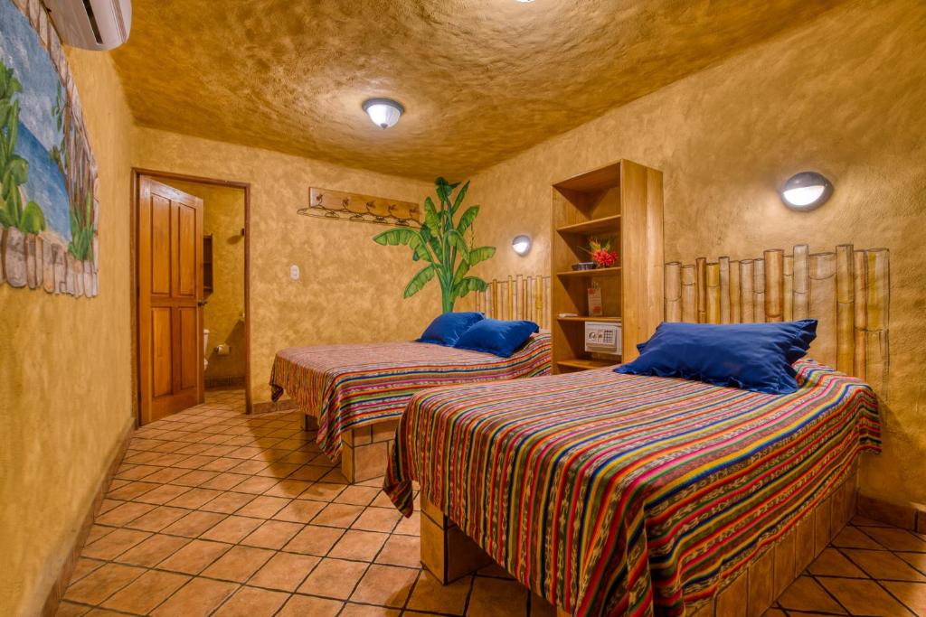 蒙特苏马El Sano Banano Beachside Hotel的一间卧室,配有两张床