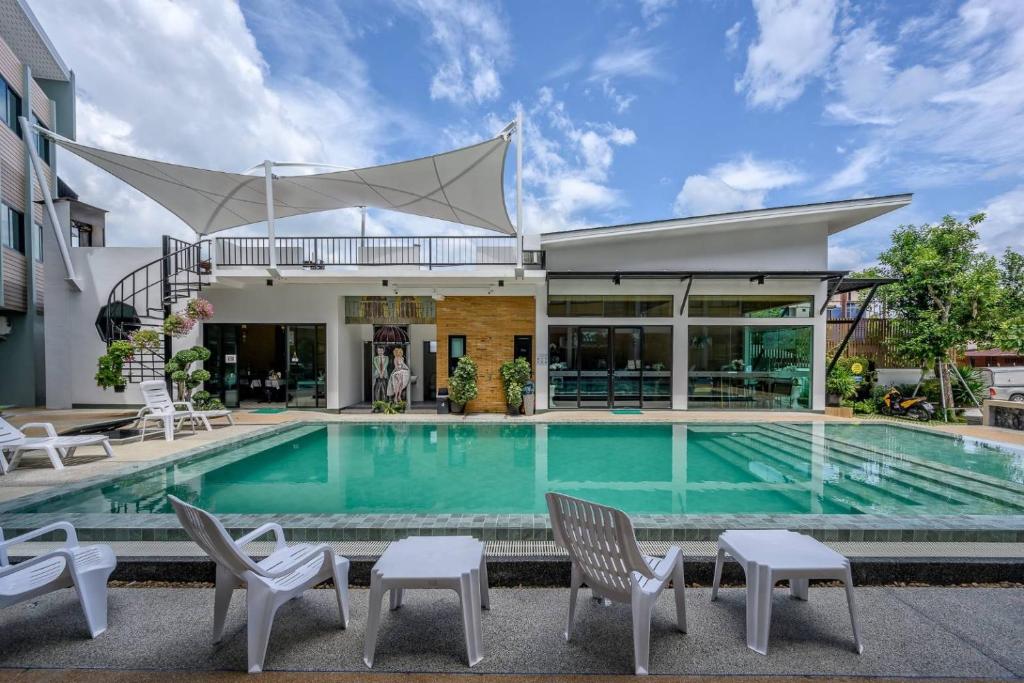奈扬海滩Phuket Airport Place - SHA Plus的一个带椅子的游泳池以及一座房子