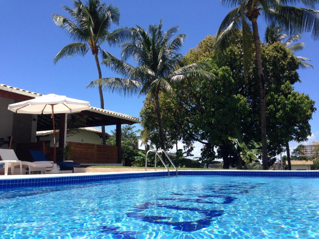 劳鲁-迪弗雷塔斯萨尔瓦多乐园酒店的一座拥有棕榈树和遮阳伞的游泳池