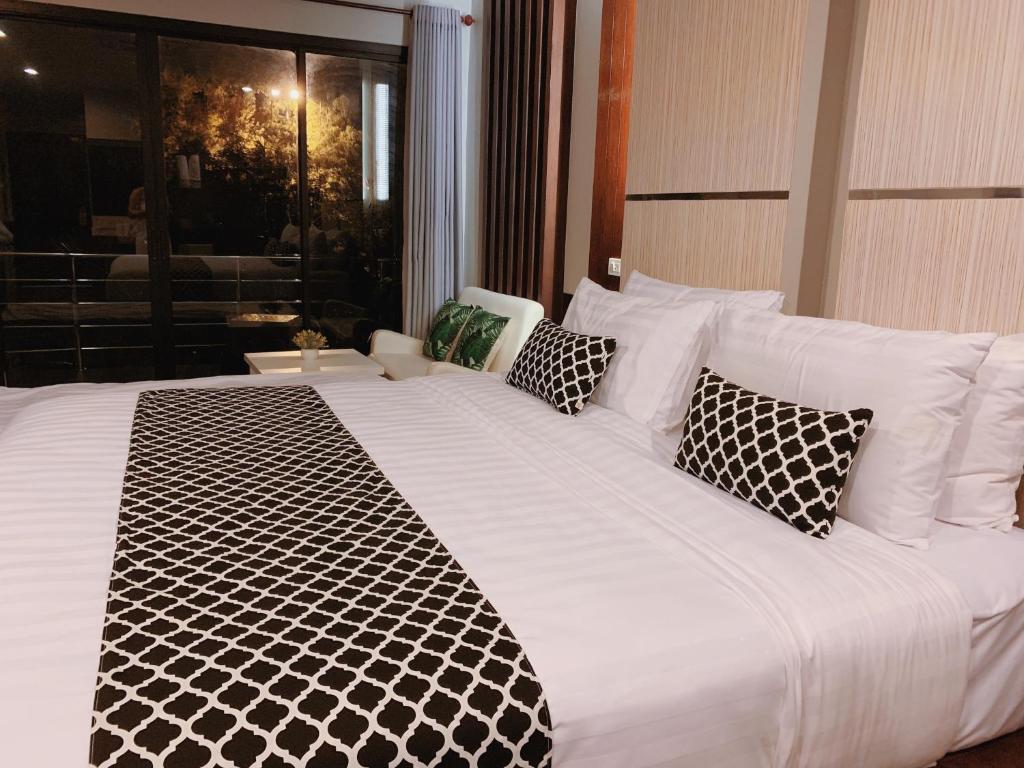 皮皮岛皮皮岛通塞酒店的一张白色大床,配有黑白枕头
