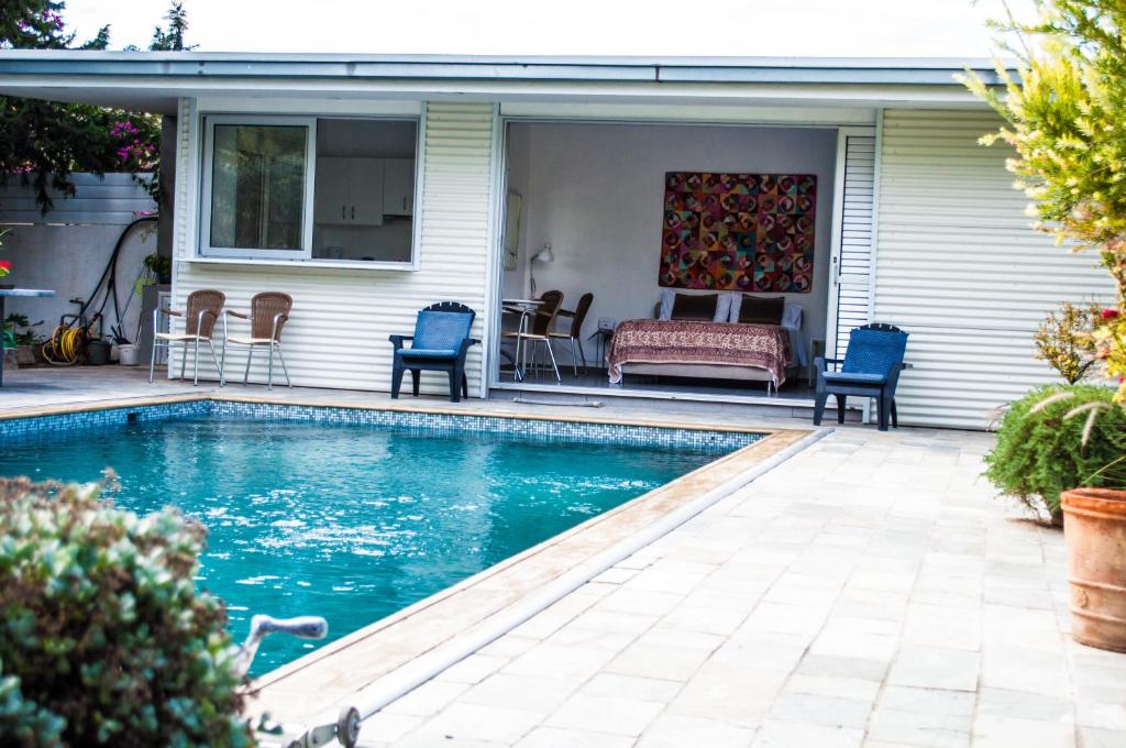 尼科西亚Idyllic studio with private pool的房屋内一个带椅子和沙发的游泳池