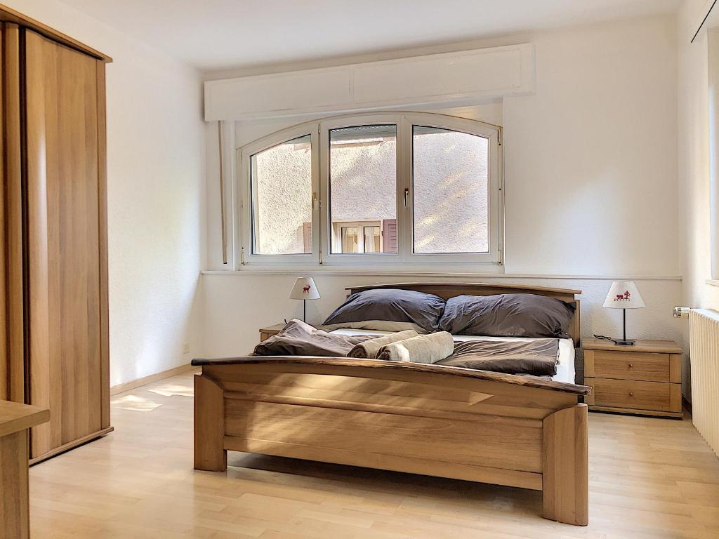 锡永Apartment Del Sol Sion Center的一间卧室配有一张木框床和窗户。