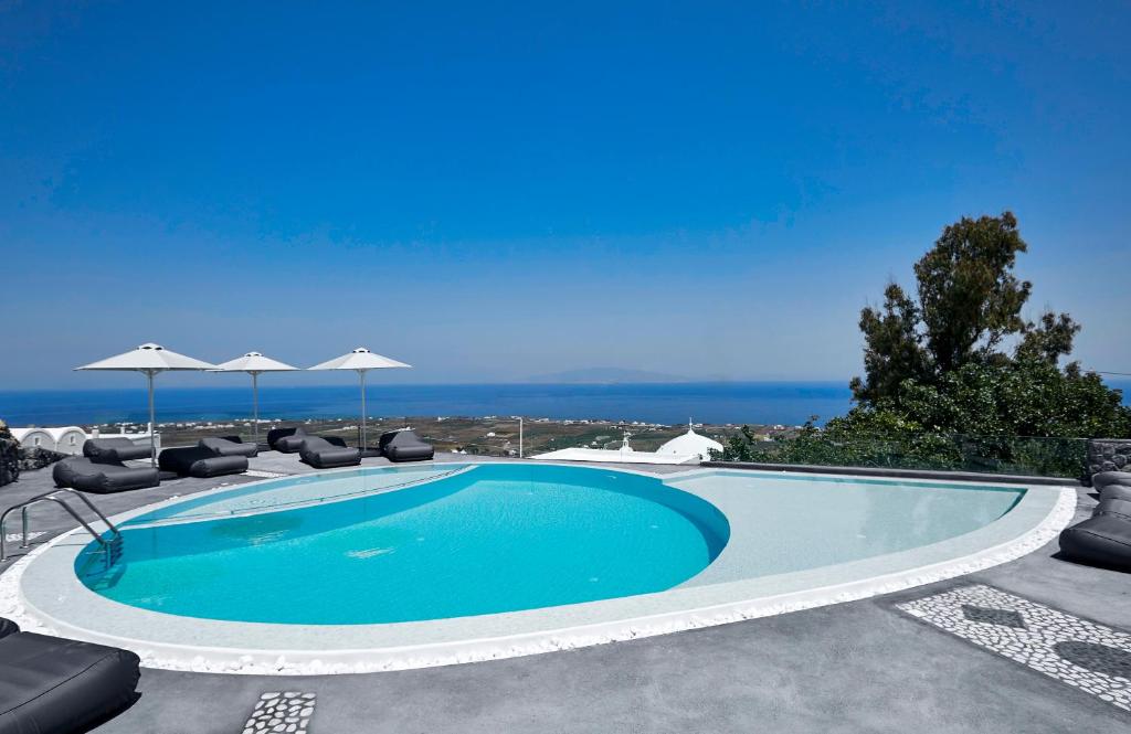 伊亚阿培兰托酒店的一个带椅子和遮阳伞的游泳池以及大海