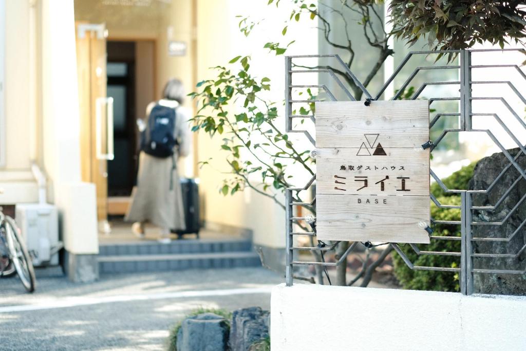 鸟取市Tottori Guest House Miraie BASE的建筑前的标志
