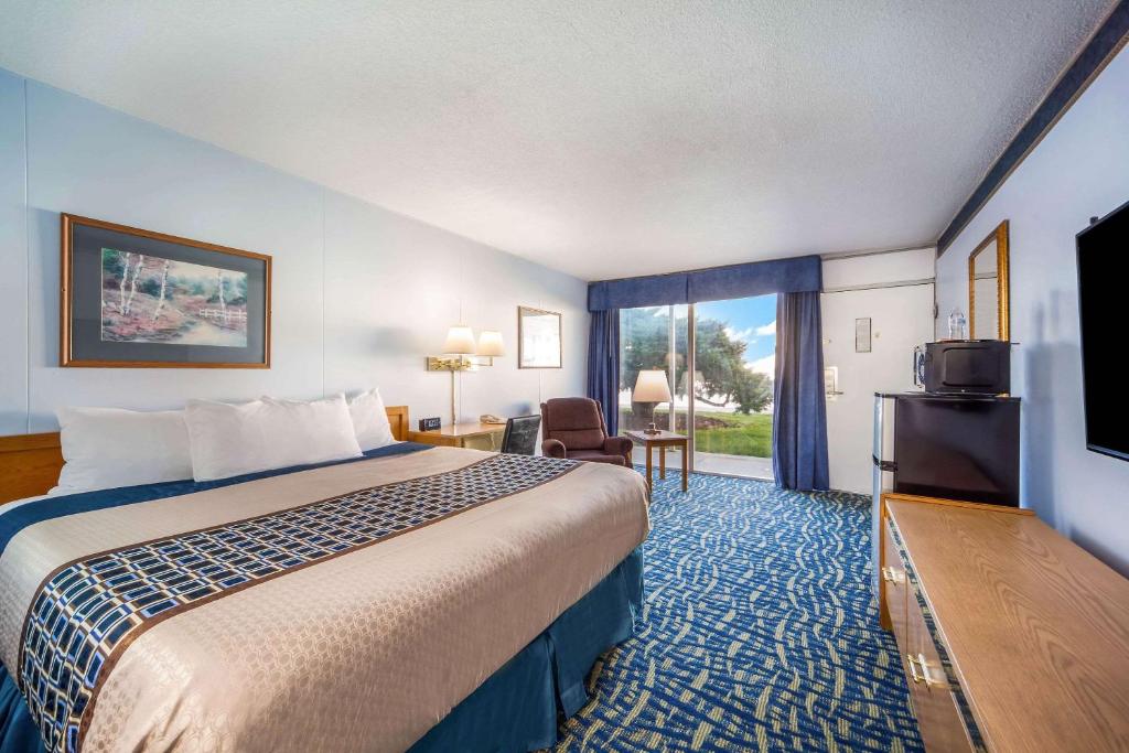 北普拉特Hospitality Inn的配有一张床和一台平面电视的酒店客房