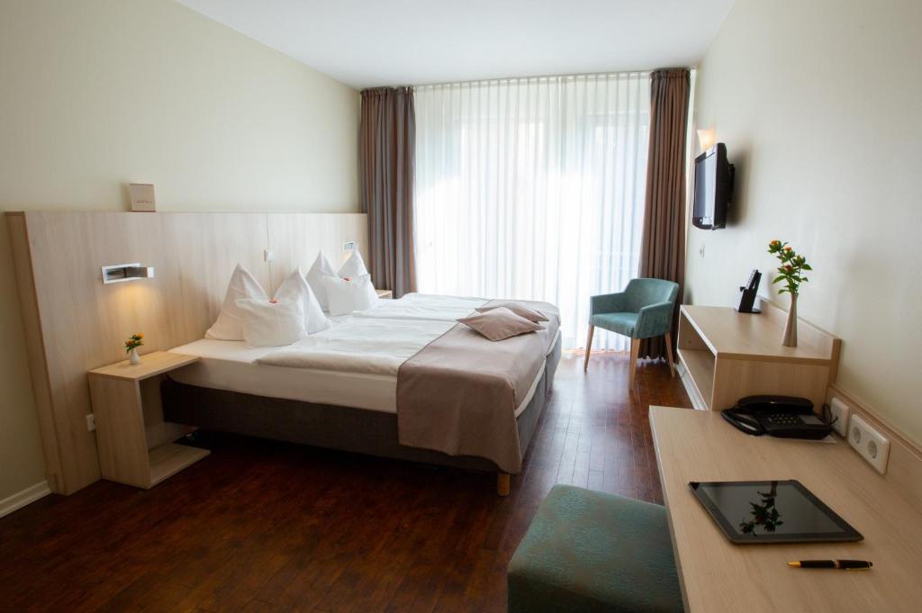 汉堡Stadthaushotel Hamburg - Inklusionshotel的配有一张床和一张书桌的酒店客房