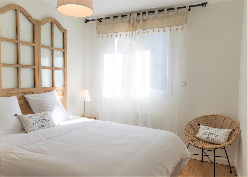 图尔Guest house " Gîte L'ATELIER DU 6"- calme - jardin的卧室配有白色的床和窗户。