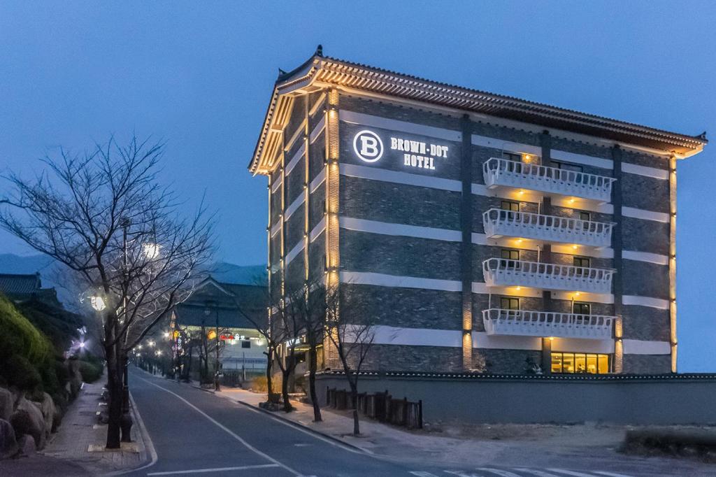 庆州Brown Dot Hotel Gyeongju的建筑的侧面有标志