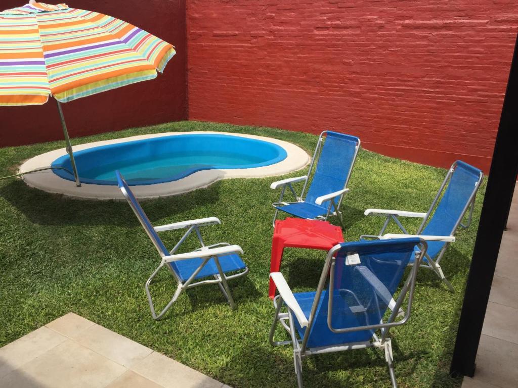圣达菲9.9的游泳池旁的三把椅子和一把遮阳伞