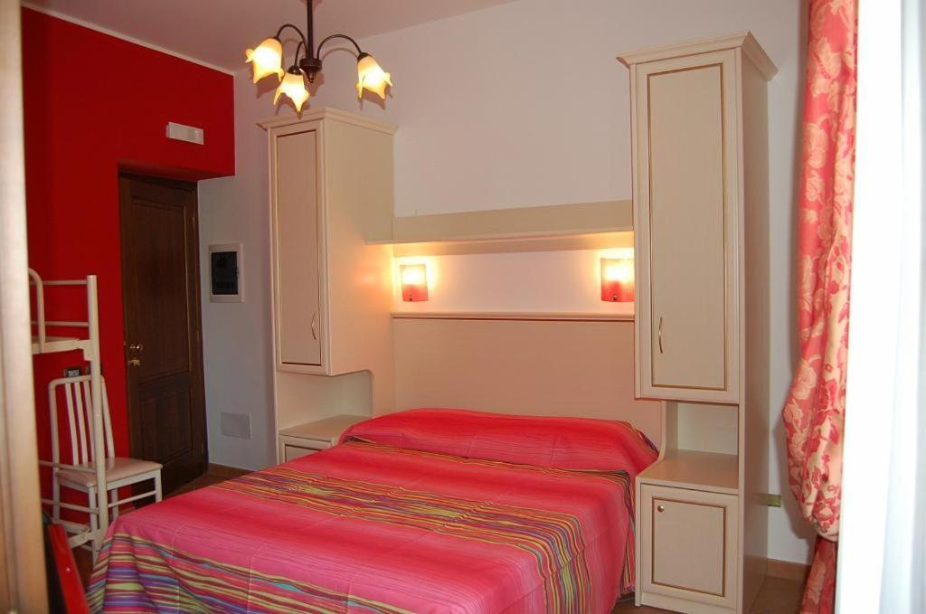 Santa Lucia del Mela帕拉农家乐的一间小卧室,房间内设有一张红色的床