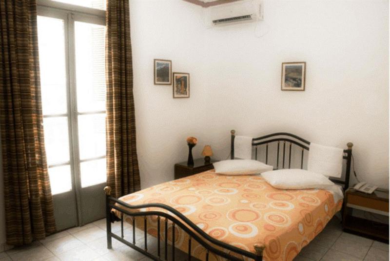 雅典阿尔戈酒店的一间卧室配有带两个枕头的床和窗户