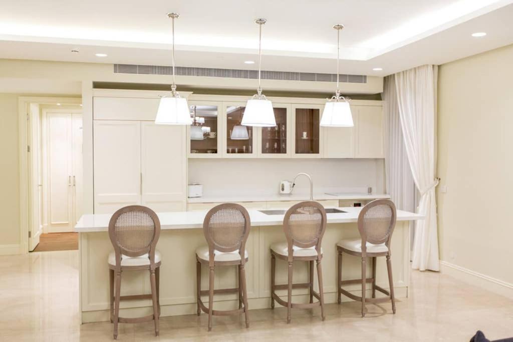 耶路撒冷SUITE WA B2 - WALDORF ASTORIA RESIDENCES - JERUSALEM-RENT的厨房四周环绕着厨房岛,配有四把椅子