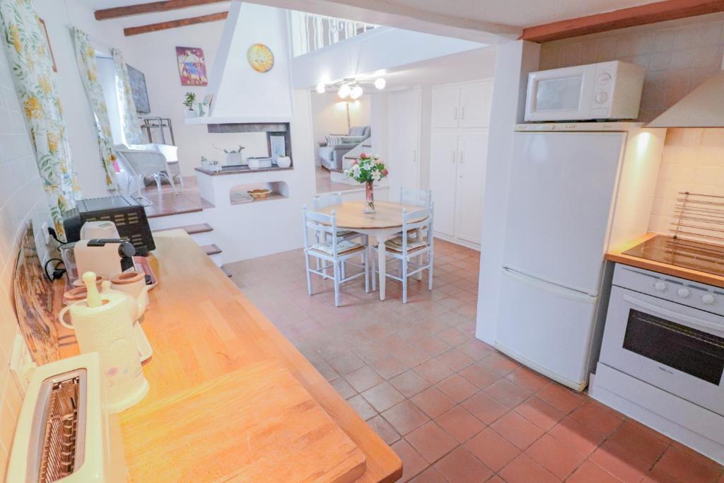 昂蒂布Duplex au coeur du vieil Antibes的厨房配有桌子和白色冰箱。