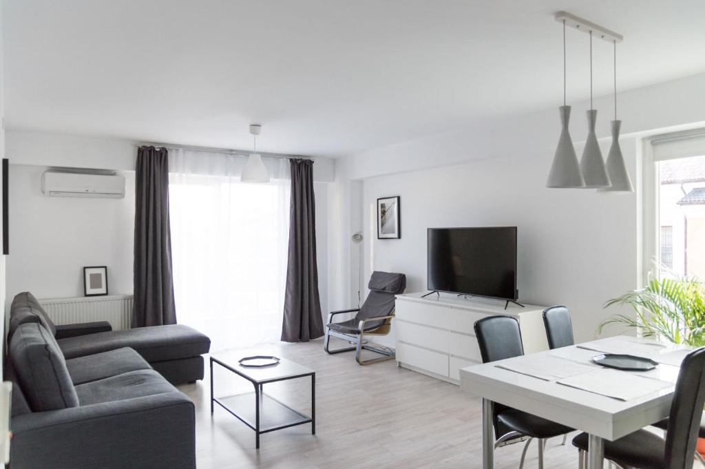 奥托佩尼Airport Residence - Apartment across from Otopeni Airport的白色的客厅配有桌子和电视。