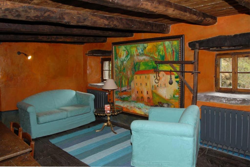 皮耶韦福斯切纳Mulino Francesco Saverio的客厅配有两把椅子和墙上的绘画