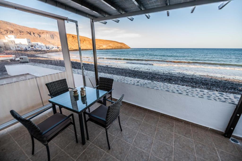 Pozo NegroTito´s Beach House的俯瞰海滩的阳台配有桌椅