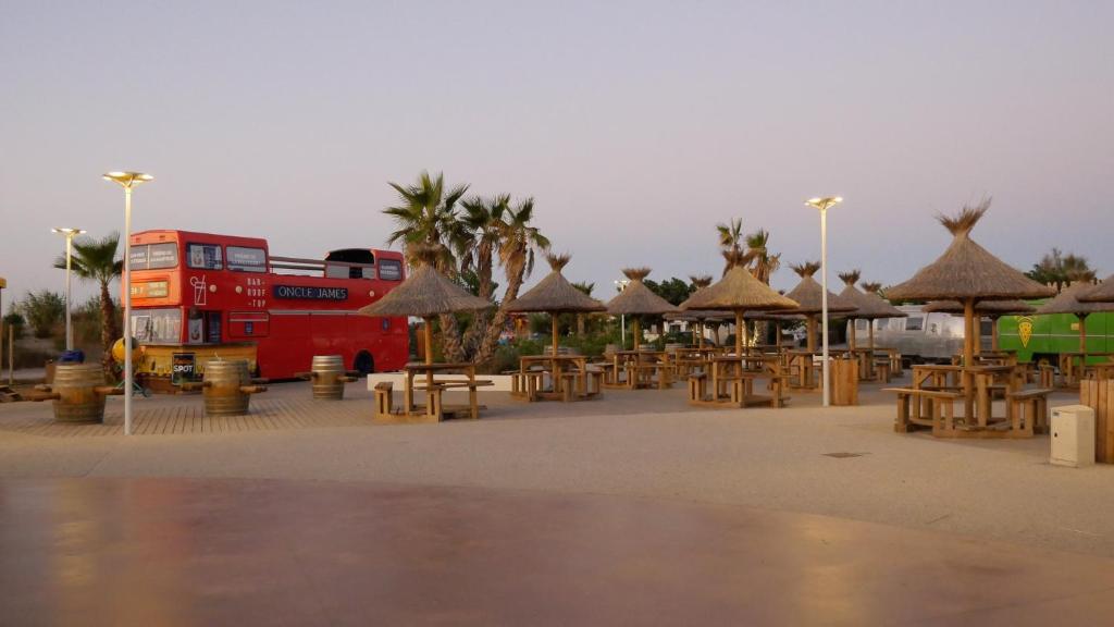 塞特港Mobil home au castellas marseillan的停在停车场的红色双层巴士