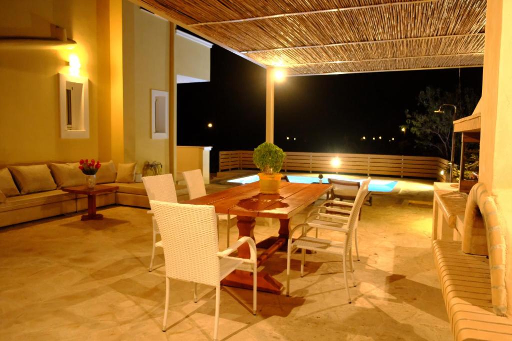 爱琴娜岛VILLA KONSTANTINOS的一间带桌子和白色椅子的用餐室
