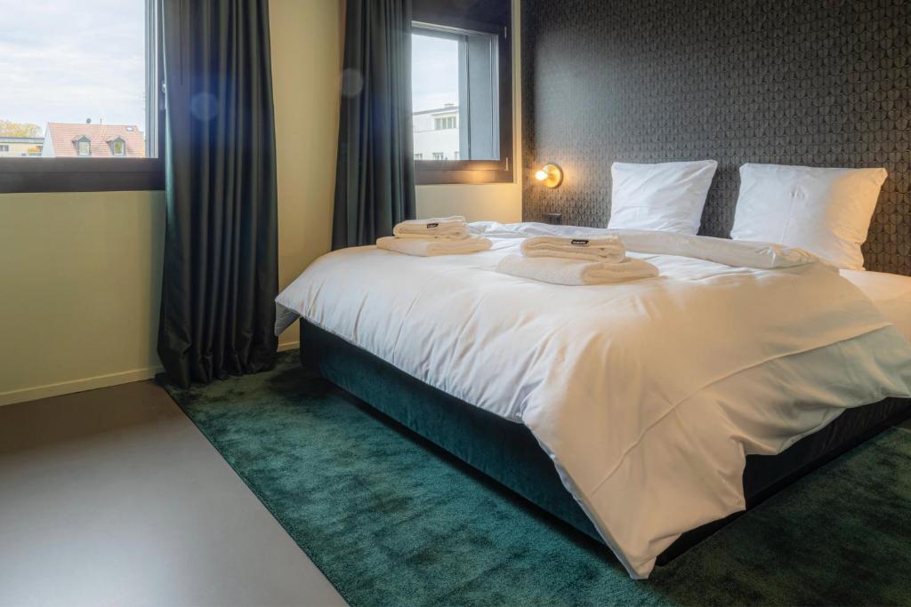 巴塞尔BLOOM Boutique Hotel & Lounge Basel的一间卧室配有一张大床和毛巾