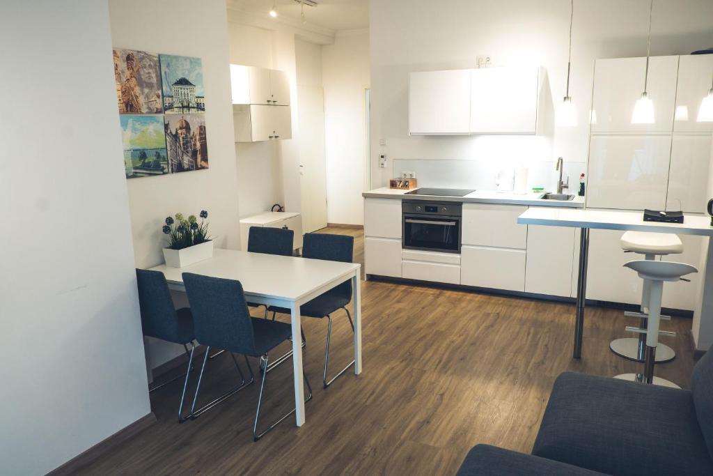 慕尼黑Stylisch eingerichtete Wohnung mitten in München!的厨房配有白色橱柜和桌椅