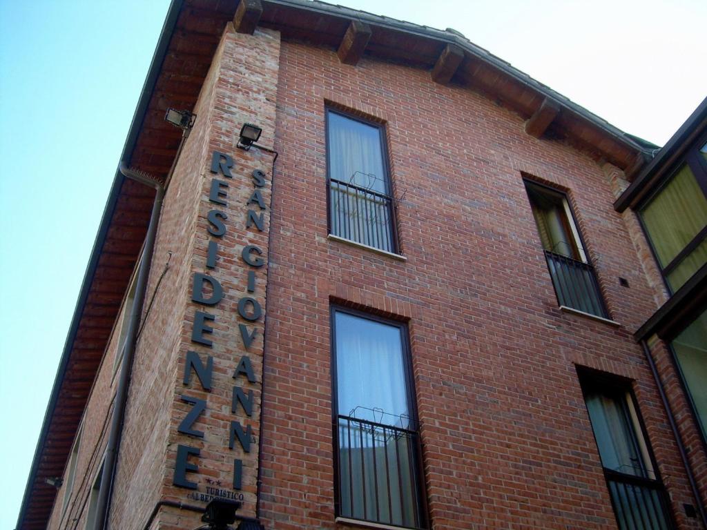 圣焦万尼瓦尔达尔诺圣乔瓦尼住宅酒店的砖砌的建筑,旁边标有标志