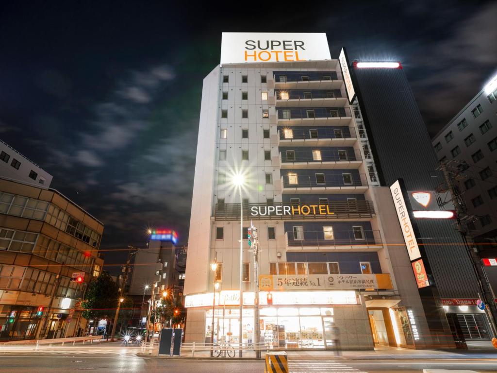 名古屋Super Hotel Nagoya Ekimae的一座酒店大楼,上面有标志