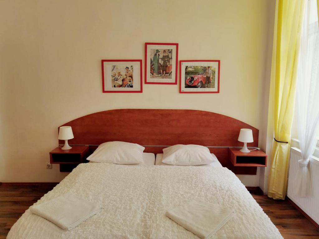布拉格阿芒德蒙特公寓的一间卧室配有一张带两盏灯的大型白色床。