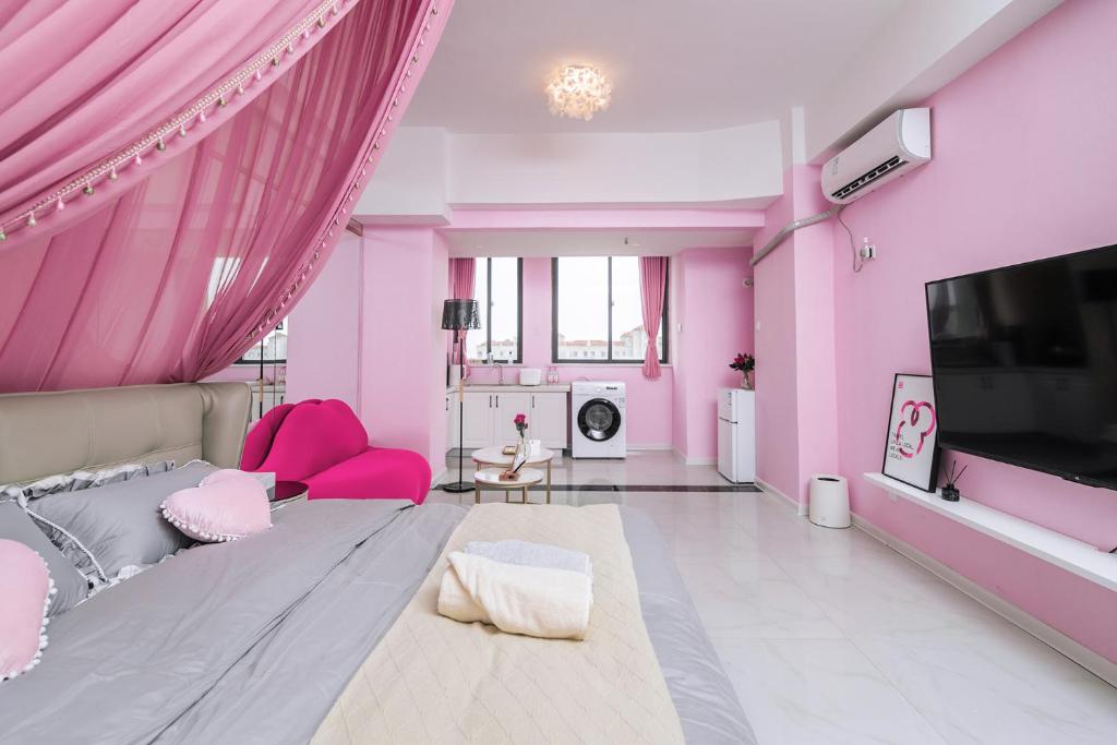 洛阳【路客】洛阳市洛龙区·宝龙城市广场·路客精品公寓·00193320的粉红色的客厅配有粉色家具和电视